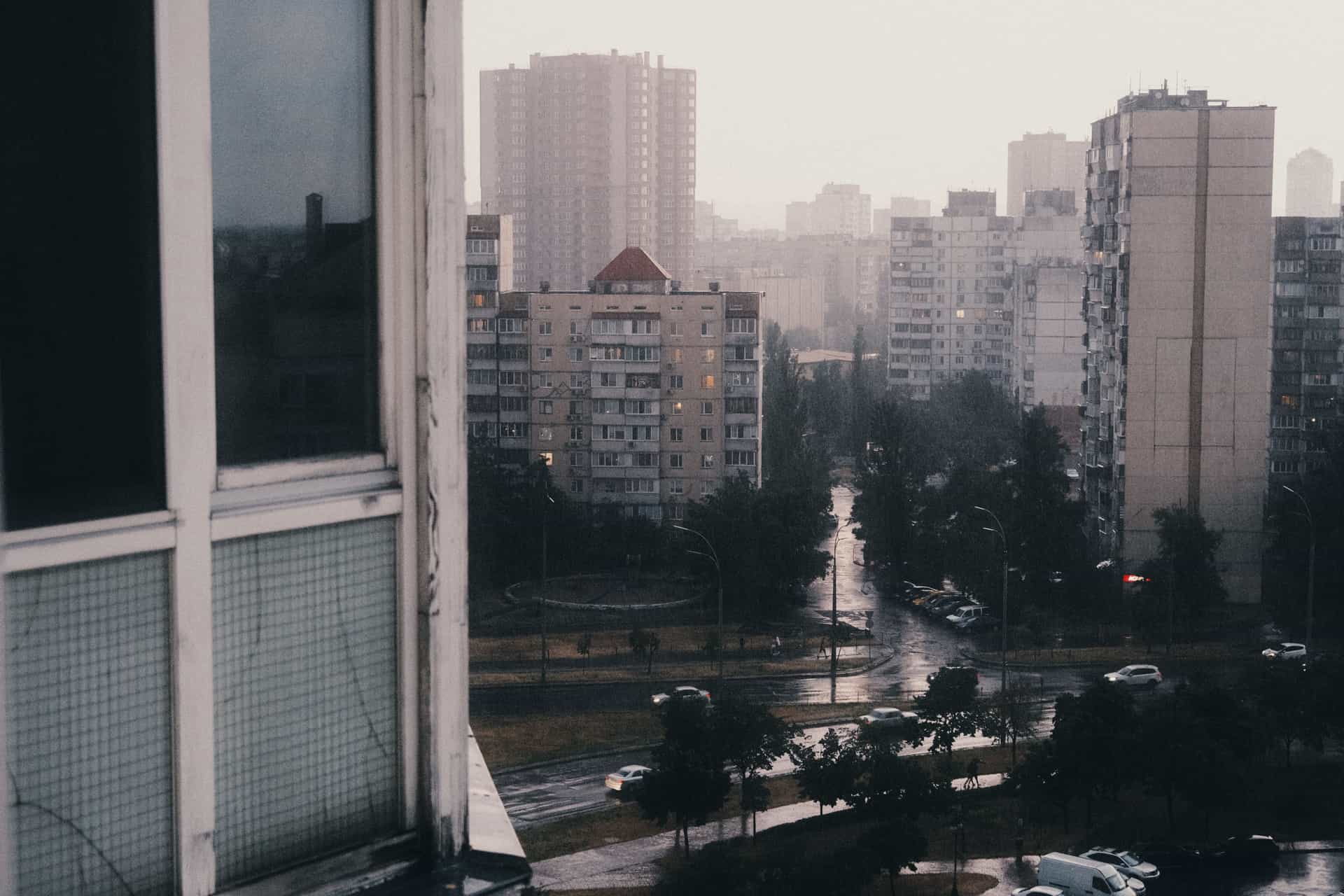 Rain running down an apartment window above a city street