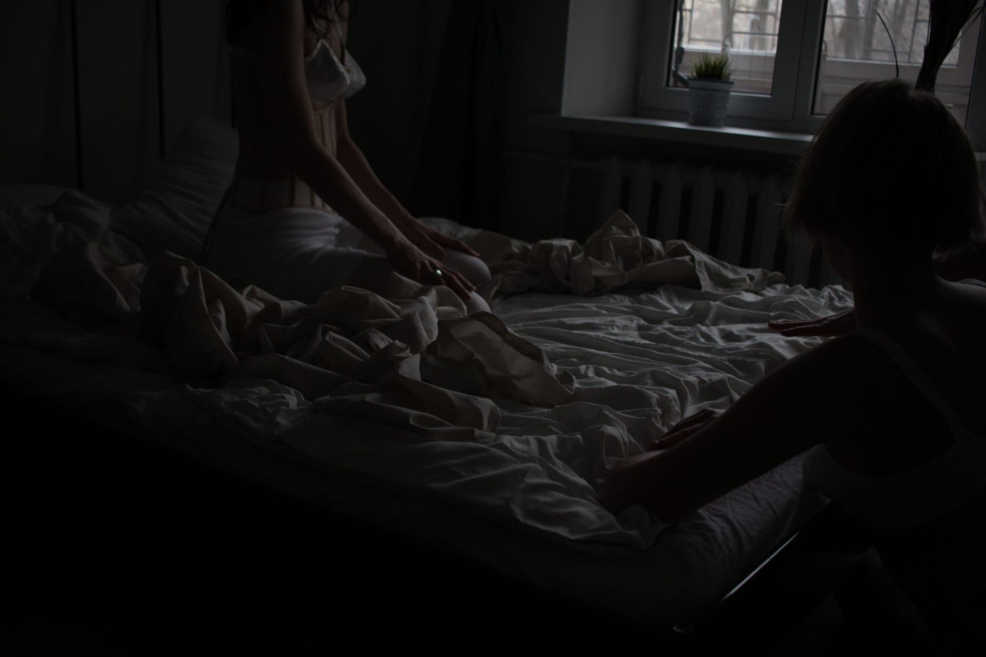 A dark, sparsely furnished bedroom at night
