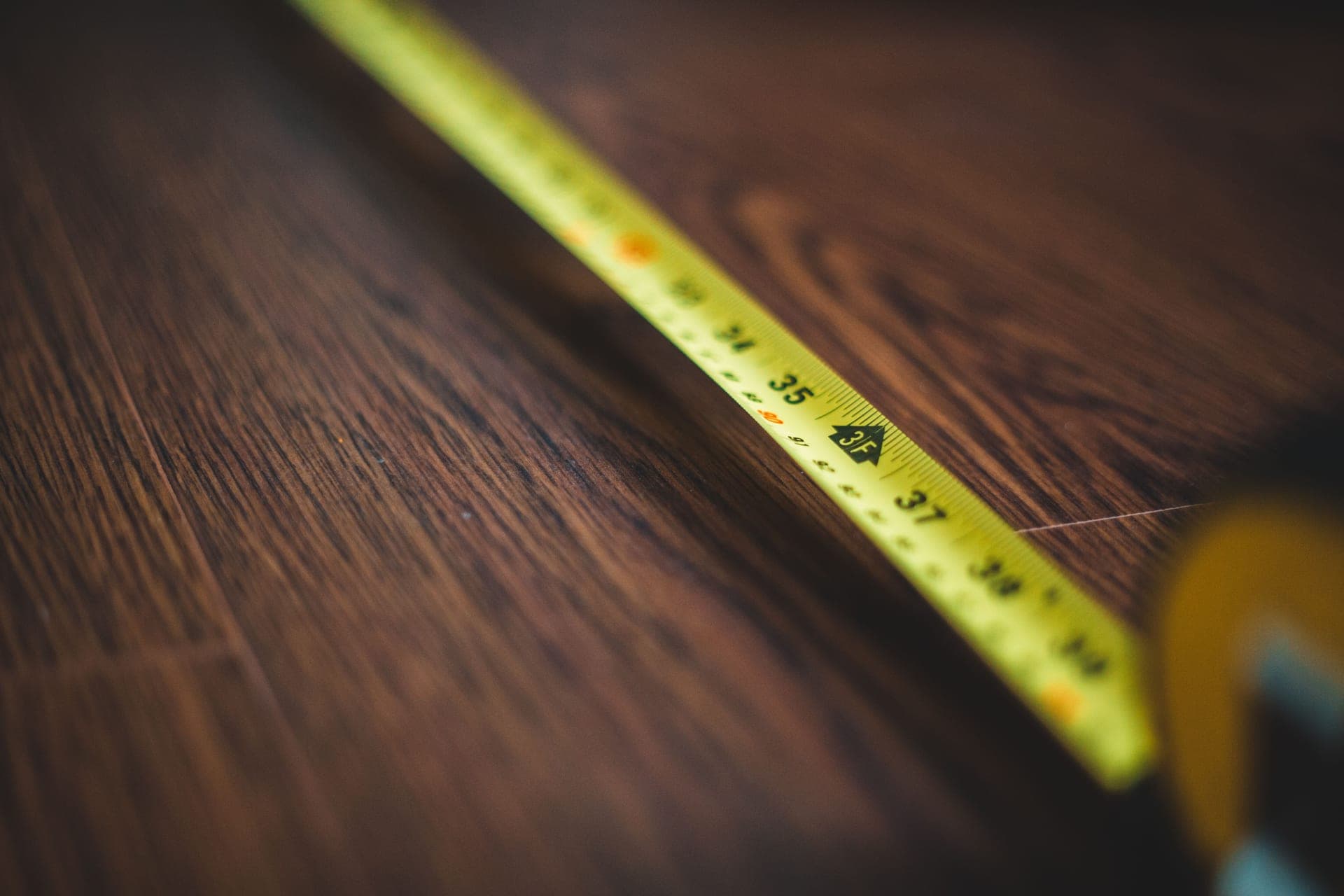 A steel tape measure lying across a bare concrete floor
